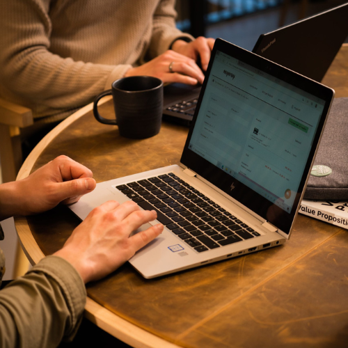 HP bærbar computer i brug ved et bord, hvor flere personer arbejder
