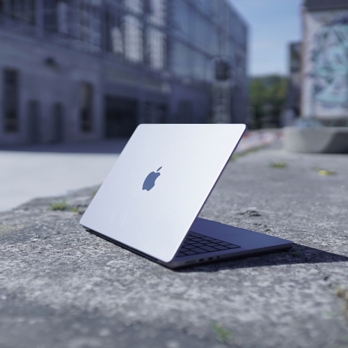 Sølvfarvet myway MacBook placeret udendørs på en betonflade