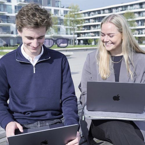 Ung mand og kvinde arbejder på hver sin myway MacBook udendørs