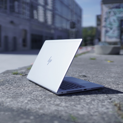 Sølvfarvet myway HP bærbar computer placeret udendørs på en betonflade