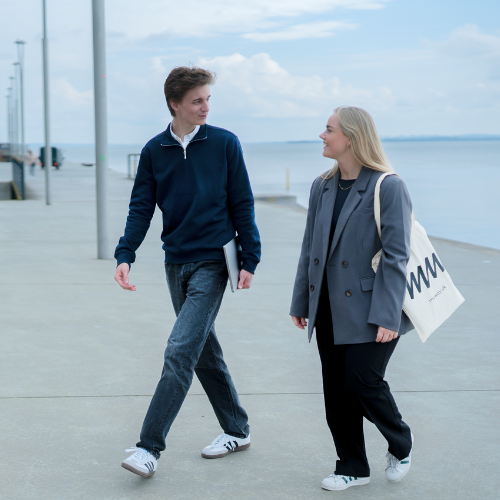 Ung mand og kvinde går sammen ved havnen med myway-taske